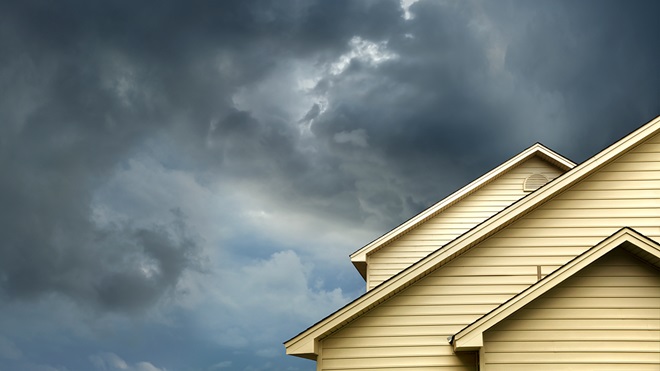 storm clouds over the roof of a home